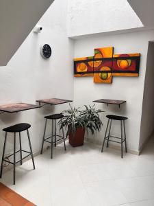 a room with tables and stools and a painting on the wall at 7 Express in Medellín