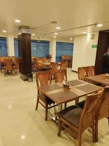 a dining room with tables and chairs in a building at RoseMallow Tavisha Hotel in New Delhi