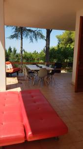 - un canapé rouge sur une terrasse avec une table et des chaises dans l'établissement VILLA LUCIA, à Matino