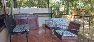 eine Veranda mit 2 Stühlen, einem Tisch und 2 Stühlen in der Unterkunft Hotel Maguey in Chilamate