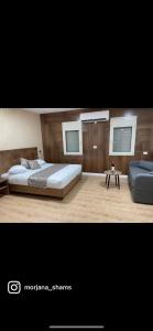 een slaapkamer met een groot bed en een bank bij Yellow House Suite in Majdal Shams