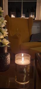 a candle on a table in a living room with a couch at Apartament DANI in Nysa