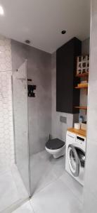 a bathroom with a toilet and a washing machine at Apartament DANI in Nysa