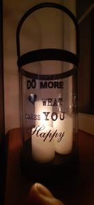a candle in a glass jar with the words do more what makes you happy at Apartament DANI in Nysa