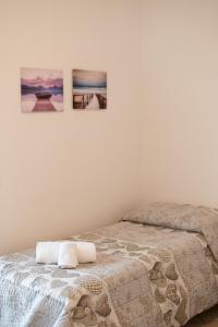 a bedroom with a bed with two pictures on the wall at Terrazza baciata dal sole in Lazise