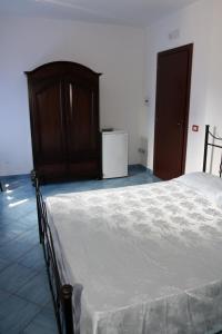 ein Schlafzimmer mit einem großen Bett und einem Kühlschrank in der Unterkunft HOTEL SANTA CLARA in Camerota