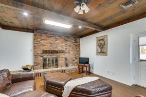 a living room with a brick fireplace and leather furniture at Historic Wheeling Condo with Fireplace Near Museums! in Wheeling
