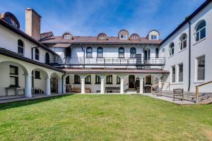 an exterior view of a large white building with a yard at Historic Wheeling Condo with Fireplace Near Museums! in Wheeling