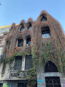 un viejo edificio con hiedra creciendo a su lado en Departamento amoblado Santiago centro en Santiago