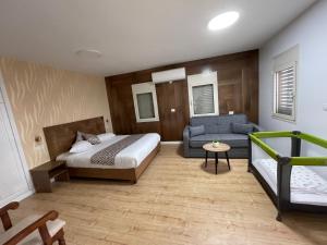 een slaapkamer met een bed en een bank bij Yellow House Suite in Majdal Shams