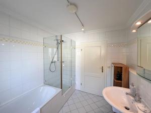 ein weißes Badezimmer mit einer Badewanne und einem Waschbecken in der Unterkunft 8 Personen I BBQ I Sunset in Herrsching am Ammersee