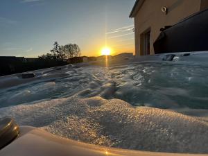 a jacuzzi tub with the sunset in the background at Maison chaleureuse tout confort in Amboise