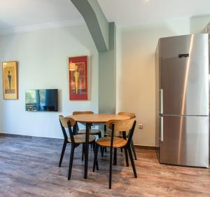 a kitchen with a table and a refrigerator at Athenian Serene City Escape in Athens