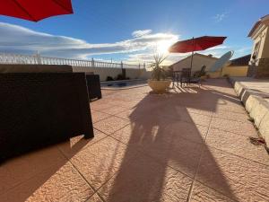 a patio with tables and umbrellas on a house at Llanos del Peral - Zurgena - sleeps 6 - R092 in Zurgena