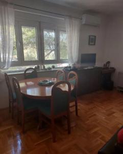 a dining room with a table and chairs and a desk at Apartment Music-center, in the center of Podgorica in Podgorica