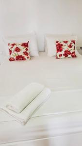 a white bed with red and white pillows at Viktora’s house in Himare