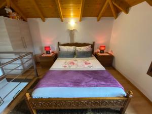 a bedroom with a bed with two lamps on two tables at ''The Stone'' in Agios Vlasios