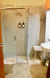 a bathroom with a shower and a toilet and a sink at Albergo Teatro in La Spezia