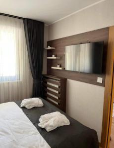 兹拉蒂博尔Zlatiborski biser lux apartmani的一间卧室，床上有两条白毛巾 更多11张照片