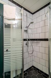 een badkamer met een douche met witte tegels bij Dizengoff square boutique in Tel Aviv