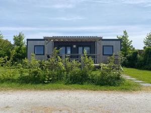 uma pequena casa ao lado de um campo em 6 person chalet in the countryside 3 bedrooms em De Veenhoop