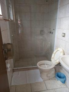 a bathroom with a shower with a toilet and a sink at Espaço Verona apartamento econômico c/banheiro e sem café p/ 1 pessoa in Fazenda Rio Grande