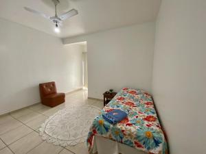 een slaapkamer met een bed en een stoel in een kamer bij Espaço Verona apartamento econômico c/banheiro e sem café p/ 1 pessoa in Fazenda Rio Grande
