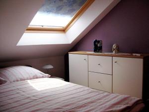 a bedroom with a bed and a skylight at Holiday home Haus Mewa in Neuenkirchen