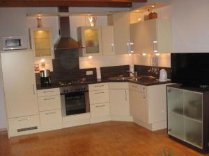 a kitchen with white cabinets and a stove top oven at Holiday home Haus Mewa in Neuenkirchen