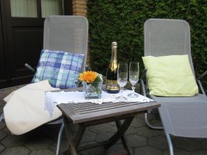 einen Tisch mit 2 Stühlen, eine Flasche Wein und Gläser in der Unterkunft Holiday home Haus Mewa in Neuenkirchen