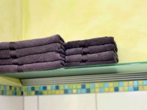 a stack of purple towels on top of a shelf at Holiday apartment in the rose garden in Birach