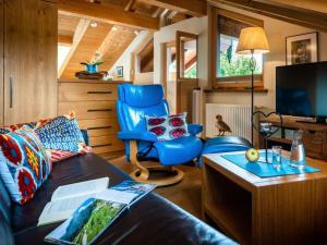 ein Wohnzimmer mit einem blauen Sofa und einem Stuhl in der Unterkunft Holiday apartment Zugspitzblick-Riedel in Garmisch-Partenkirchen
