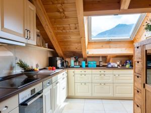 eine Küche mit weißen Schränken und einem großen Fenster in der Unterkunft Holiday apartment Zugspitzblick-Riedel in Garmisch-Partenkirchen