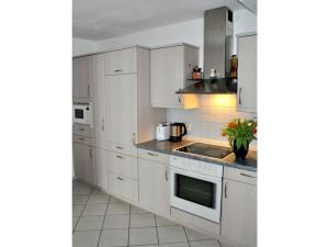 a kitchen with white cabinets and a sink at Holiday apartment Resch in Perlesreut