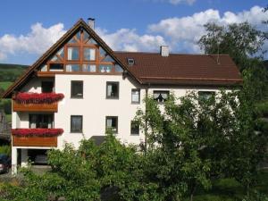 a large white house with a brown roof at Bohn - Apartment 2 in Gersfeld