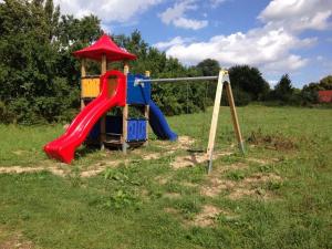 a playground with a slide in a field at Holiday home Lutowsee 