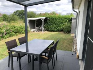 a table and chairs on a patio with a view of a yard at Holiday home Lutowsee 