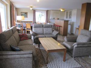 a living room with couches and a table and a kitchen at Holiday home Eckstein in Oy-Mittelberg