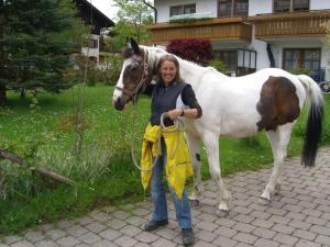 a woman standing next to a brown and white horse at Holiday home Eckstein in Oy-Mittelberg