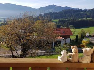 three teddy bears sitting on top of a wooden bench at Holiday home Eckstein in Oy-Mittelberg