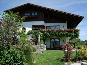 a house with flowers on the side of it at Holiday apartment Hildegard birds in Oberreute