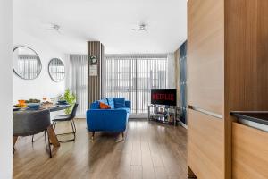 a living room with a table and a blue chair at Bullring Lux Suite, New Street Free Netflix - Free Secure Parking- Sleeps 6 in Birmingham