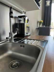 a stainless steel kitchen sink in a kitchen at Modern apartment near Helsinki airport in Vantaa