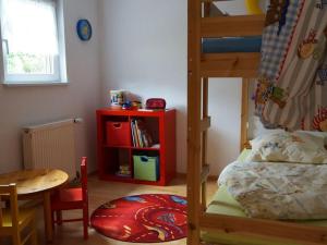 a small room with a bunk bed and a table and a tableablish at Holiday apartment holidays in the forest in Weisenbach