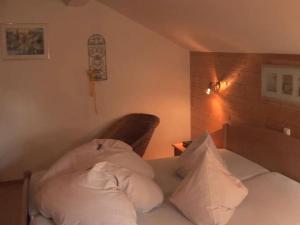 1 dormitorio con 1 cama con almohadas blancas en Holiday apartment Waxenstein, en Lenggries