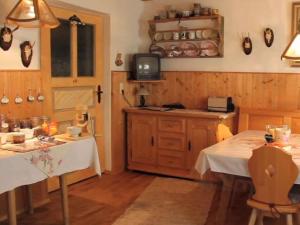 cocina con 2 mesas y TV en una habitación en Holiday apartment Waxenstein, en Lenggries