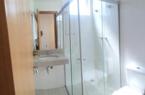 a bathroom with a glass shower and a sink at Lord Hotel Aeroporto Confins in Vespasiano