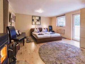 ein Schlafzimmer mit einem Bett, einem Sofa und einem TV in der Unterkunft Idyll near Limburg Lahn in Hünfelden