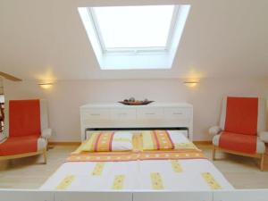 a bedroom with a bed and two red chairs at Holiday apartment Gelting in Gelting