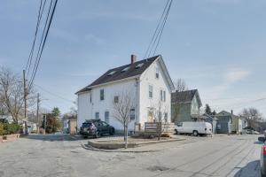una casa bianca con un tetto nero su una strada di Bright and Pet-Friendly Home 2 Mi to Harvard Square a Watertown
